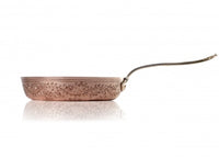 A fine copper fry pan that harkens back to Roman elegance.  The classic look of the 9-inch “Leaves” Copper Fry Pan adds an elevated charm to your kitchen. Winding leaf designs cover the gleaming exterior of this fry pan. Made entirely from hand hammered copper, this copper cookware piece features a double layer of tin lining. Applied by hand, the tin layers provide an even protective coating that keeps your fry pan from wearing down.