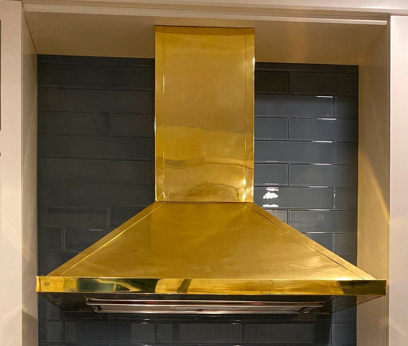 Polished brass range hood in a beautiful kitchen